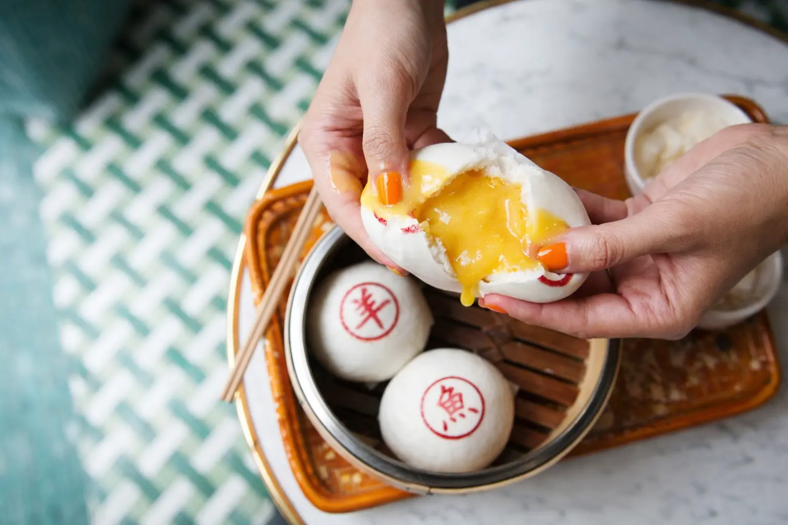 Custard bun split open over a bamboo steamer in Chinatown